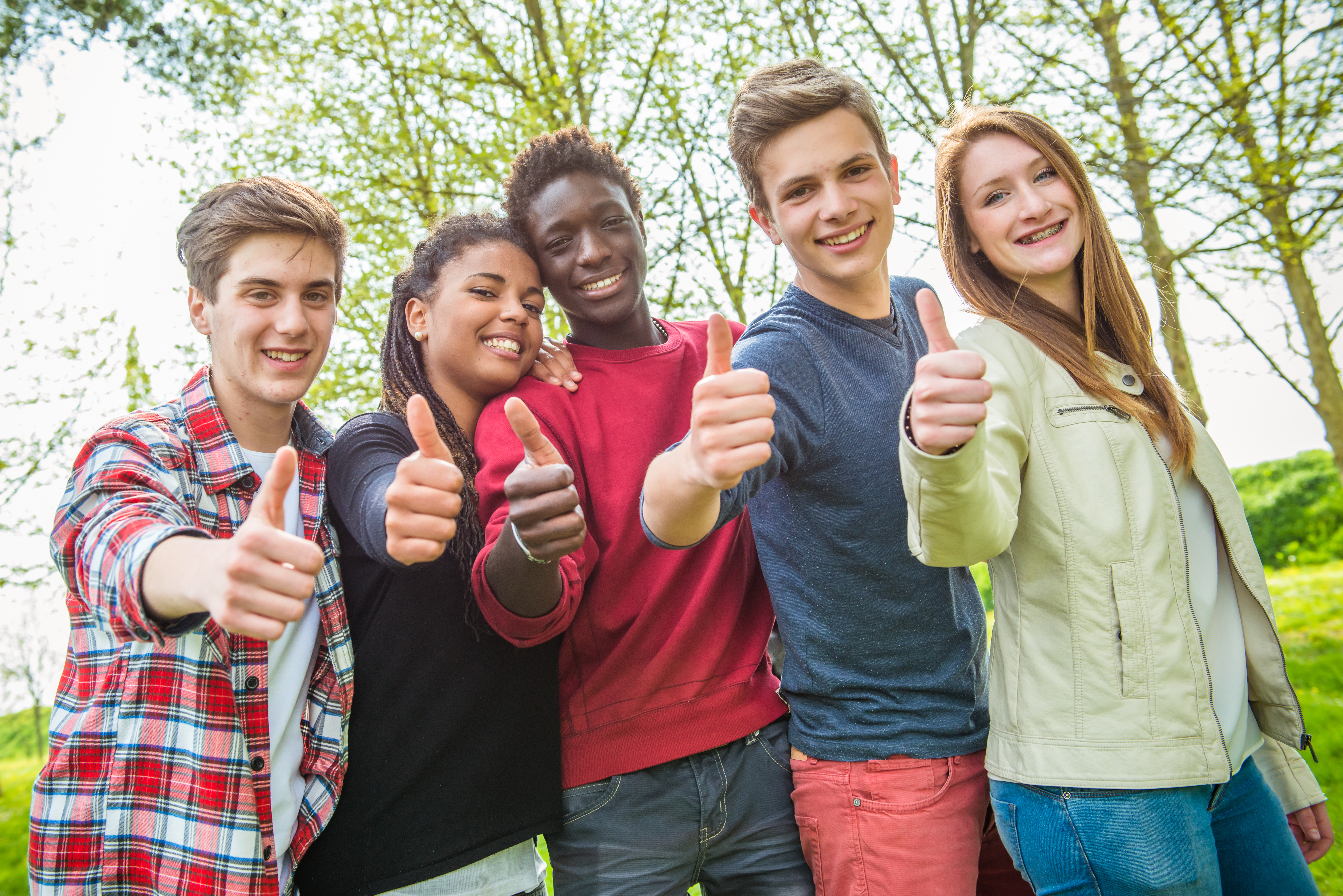 3 jongens en 2 meiden van 16 jaar oud, met een duim omhoog als dikke duim teken